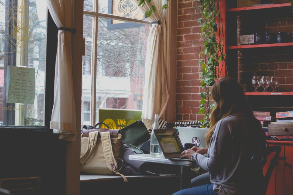 Frau arbeitet in einem Café an einem Laptop