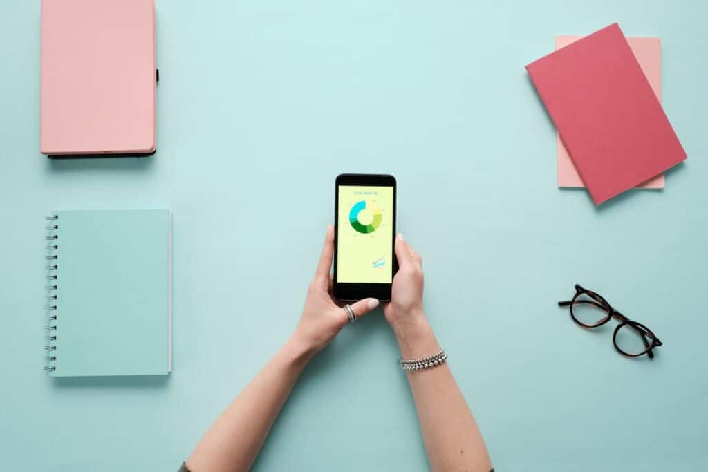 deux mains tenant un smartphone comprenant un graphe en camembert