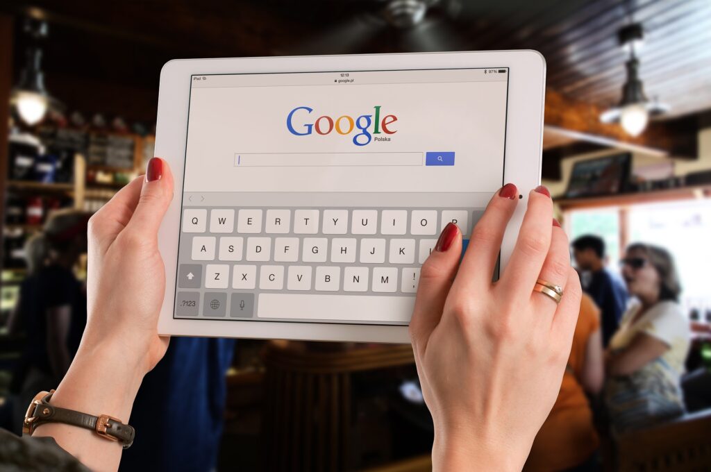 Femme tenant une tablette avec la page de recherche Google dessus