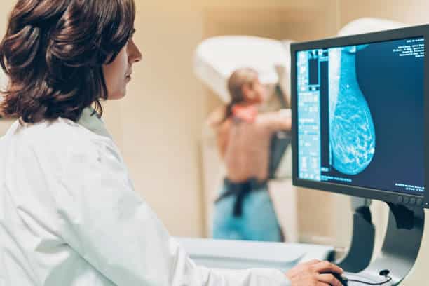 Un docteur et sa patiente effectuant une mammographie