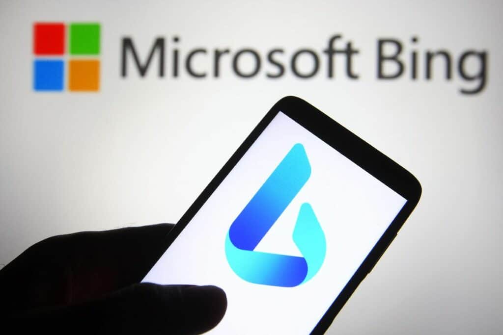 Téléphone portable avec le logo Bing dessus et le logo et nom microsoft Bing flouté en arrière