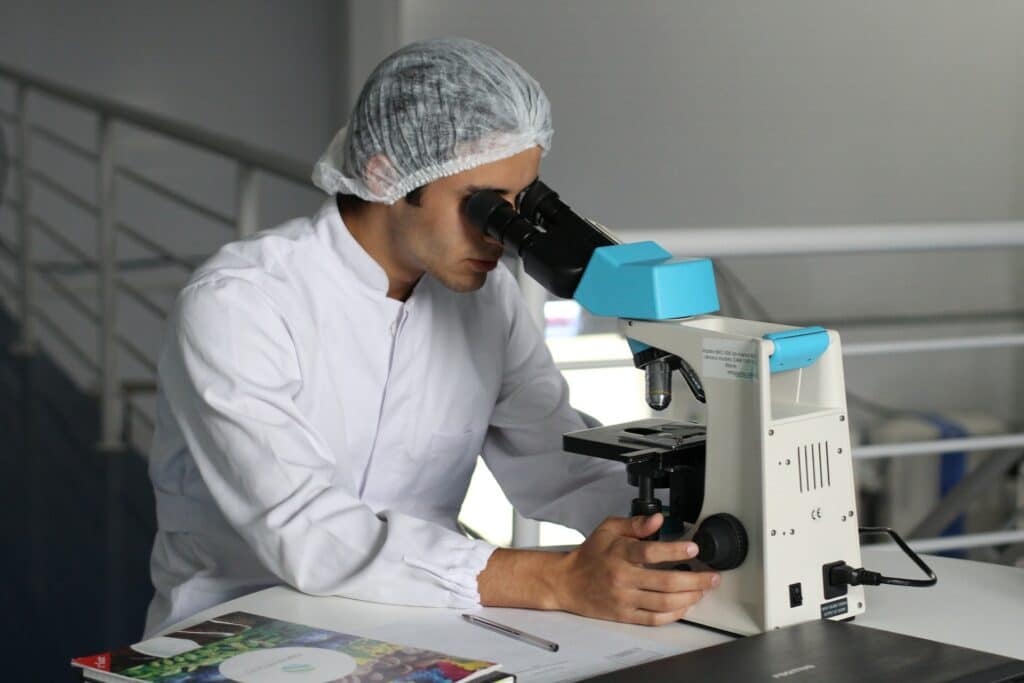 Scientifique observant des cellules au microscope