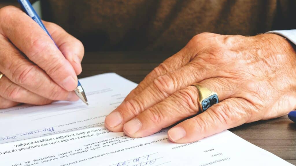 Personne âgée signant un papier administratif