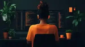 Une développeuse travaille sur plusieurs écrans affichant du code, dans un environnement de bureau calme et décoré de plantes vertes. Elle porte un casque audio et un t-shirt orange, concentrée sur la programmation. Ce cadre évoque des concepts liés à l'architecture logicielle, comme l'event sourcing.