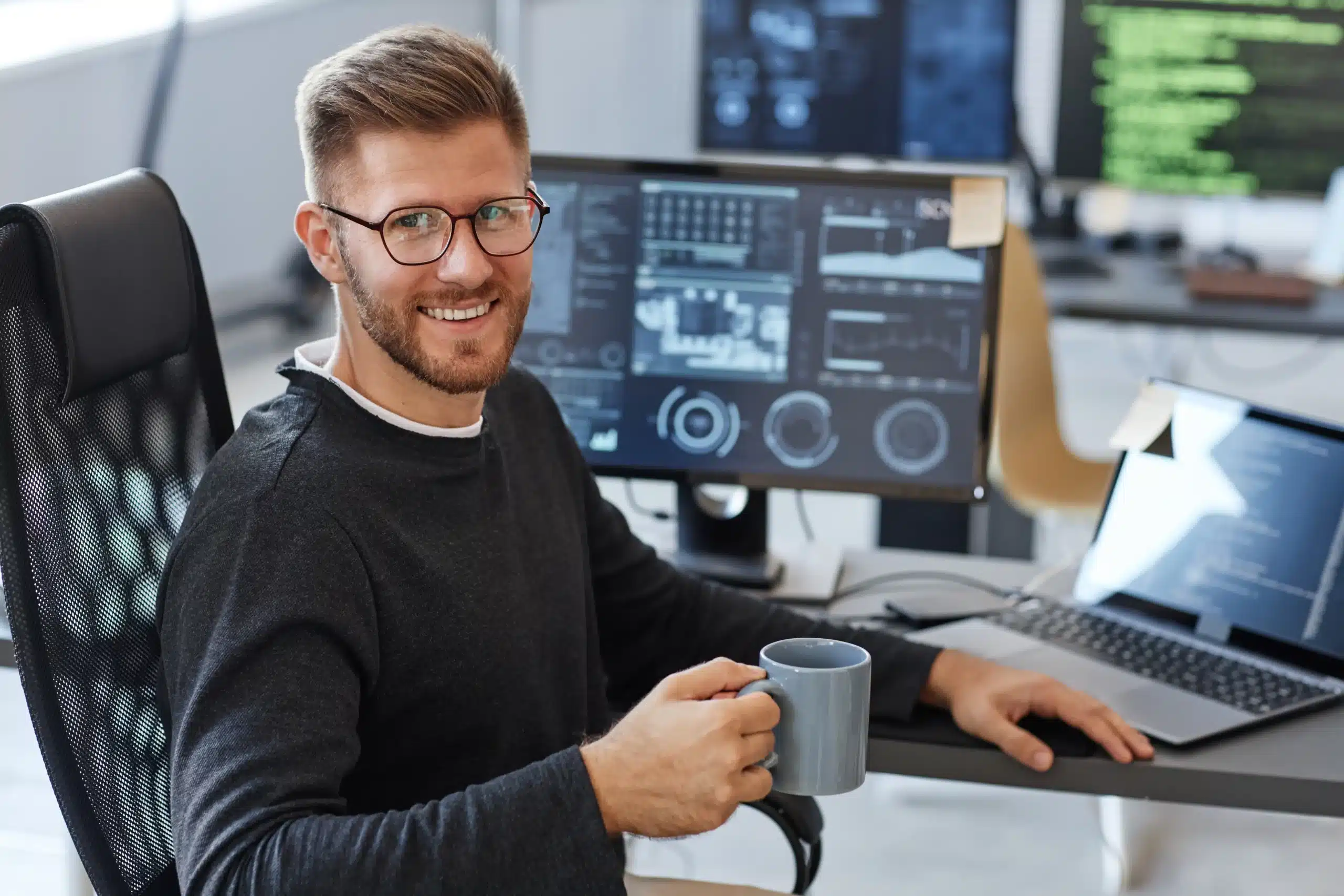 Étudiant en alternance IA travaillant sur un projet de data science dans un bureau équipé de plusieurs écrans.