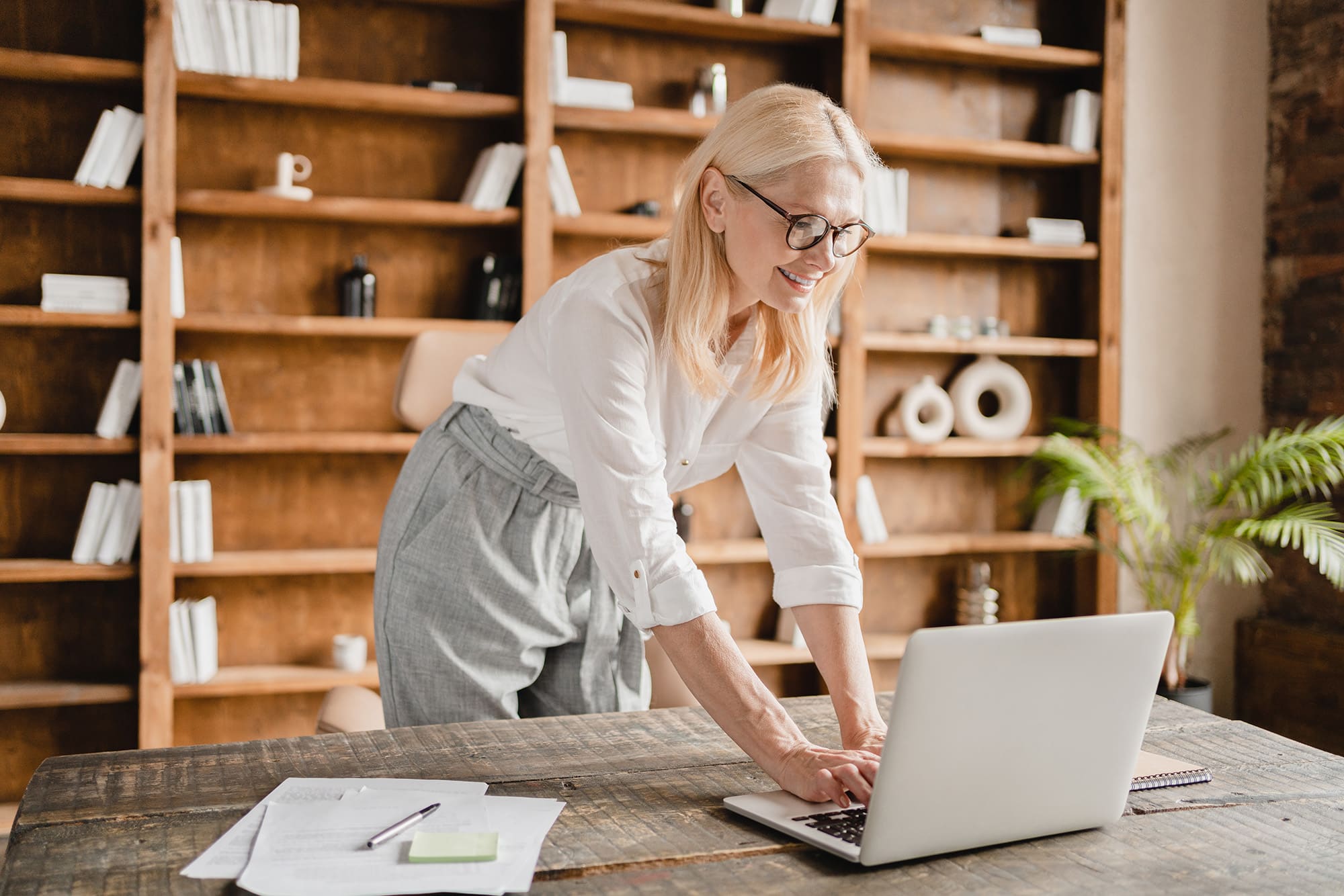 Recruteuse expérimentée travaillant sur un ordinateur portable dans un bureau chaleureux, représentant l’expertise d’un cabinet de recrutement data dans l’analyse des candidatures.