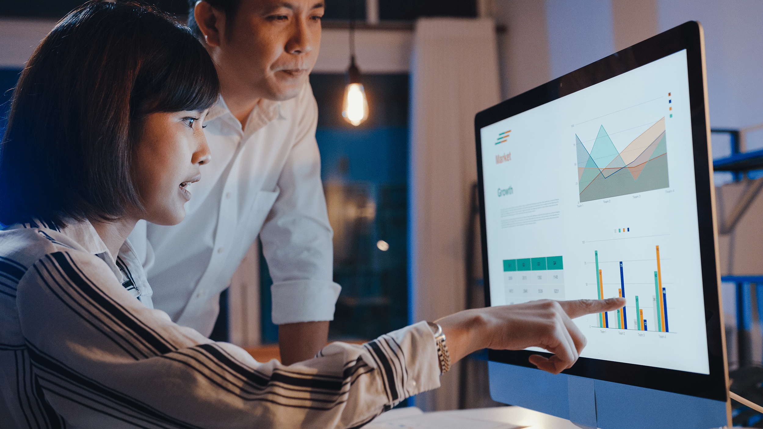 Employée montrant sur son écran un dashboard, outil indispensable pour un Data Analyst, afin de visualiser les données avec son manager.