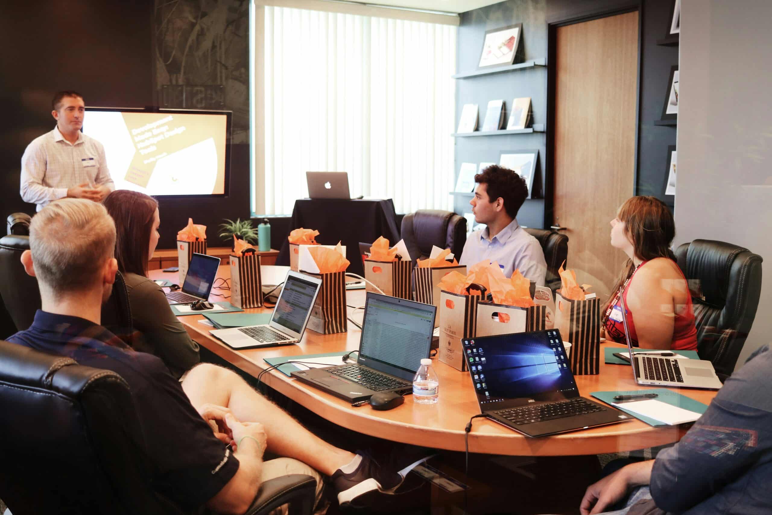 Atelier de formation sur Webflow en entreprise, avec présentation et participants utilisant des ordinateurs portables.